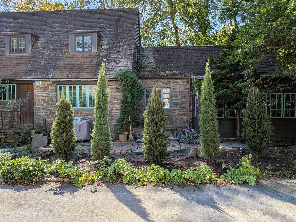 Stone home entrance with evergreen plantings